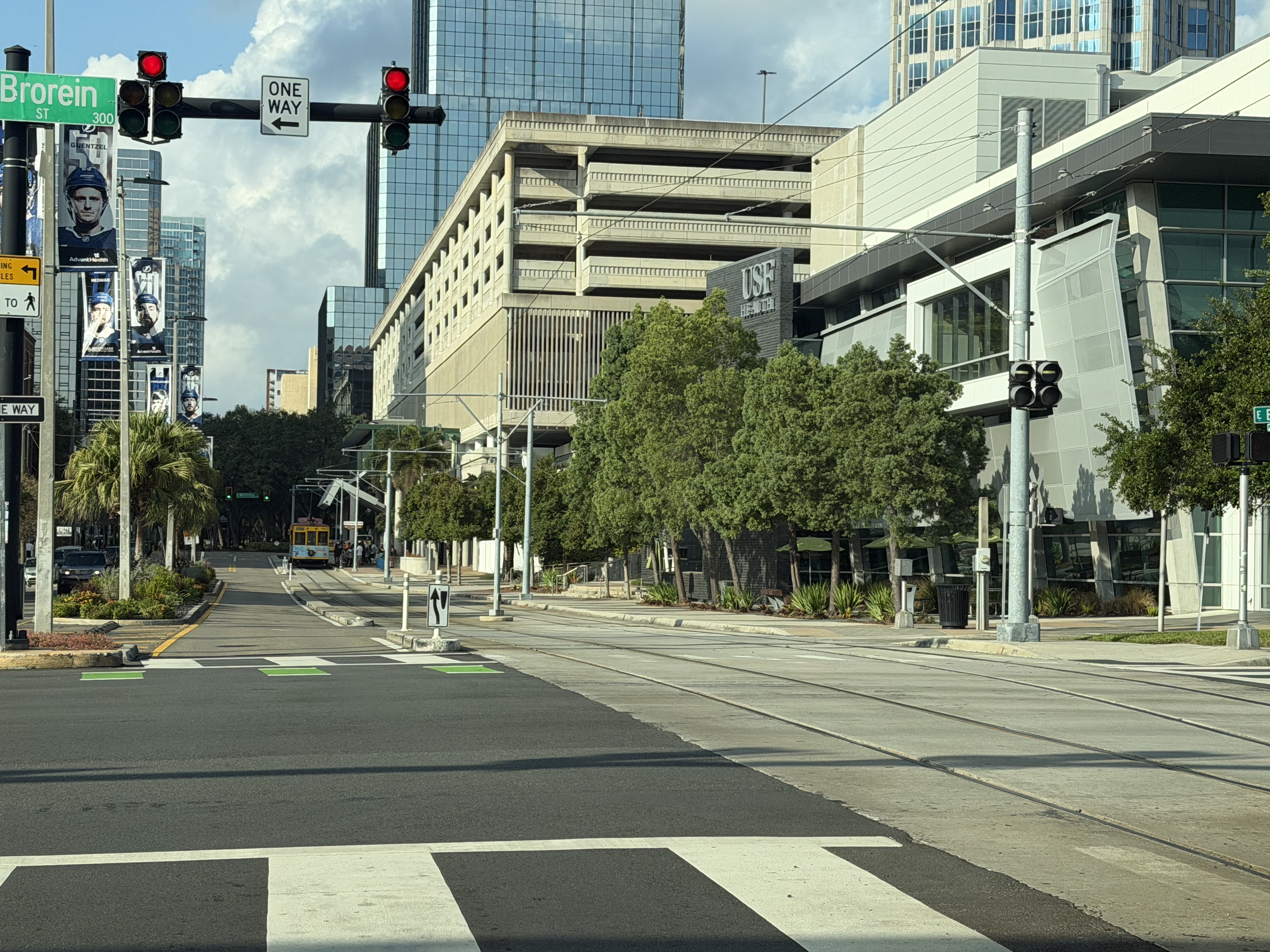 Urban downtown signalized rail crossing at Brorein Street with traffic signals and crosswalk markings