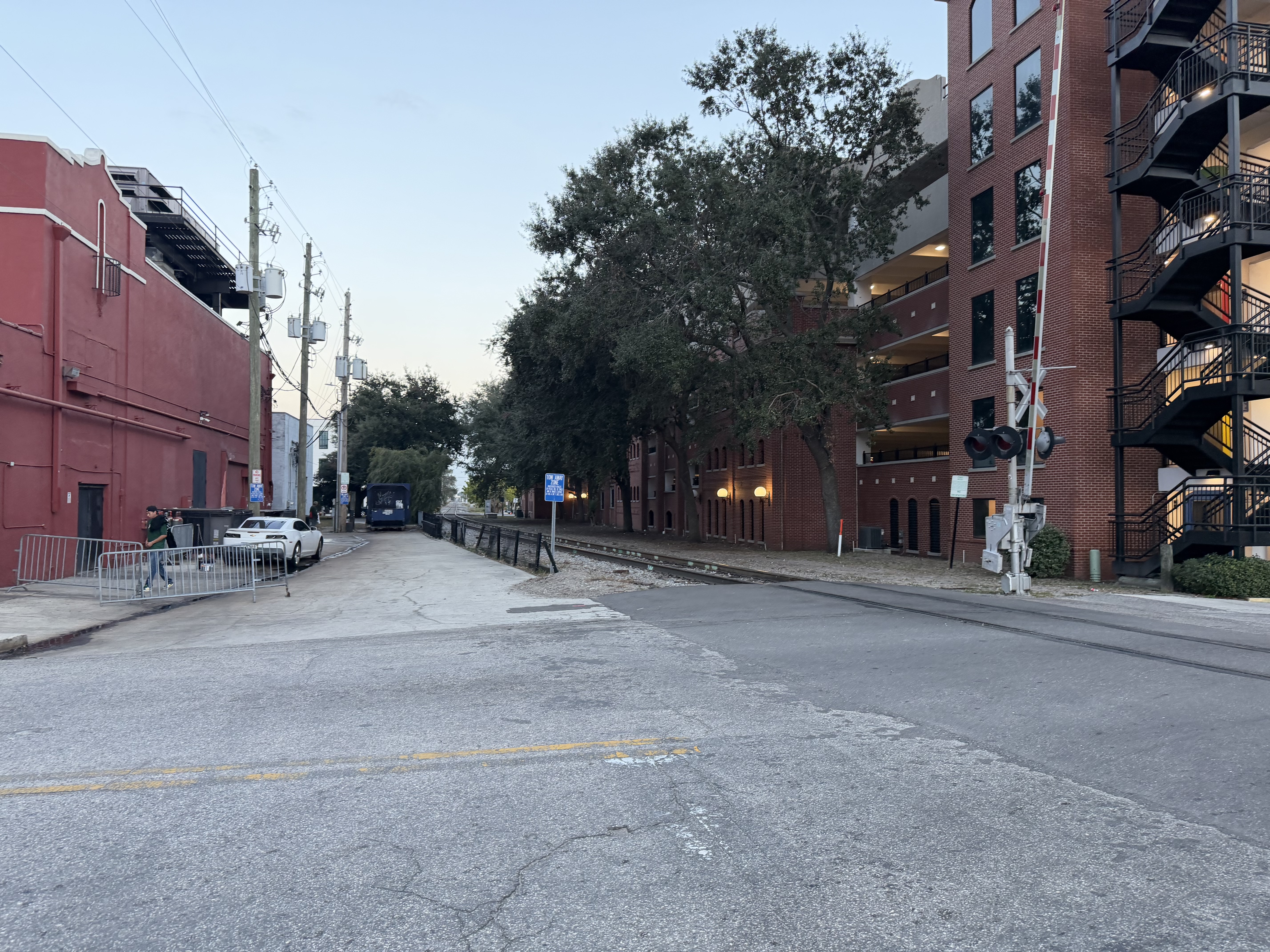 Urban narrow street rail crossing between buildings with flasher signal